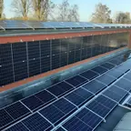 Photovoltaik an Dach und Fassade eines roten Gebäudes