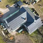 Luftaufnahme: Zweifamilienhaus mit Solarmodulen auf mehreren Dachflächen