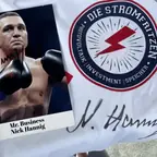Signiertes Foto des Boxers Nick Hannig neben einem T-Shirt mit dem Stromfritzen-Logo