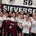 Fußballmannschaft der SG Sieversdorf vor dem Vereinsbanner, vorn ein dunkelrotes Trikot
